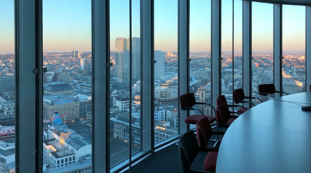 A photo of the internal aspect of a London office with floor to ceiling glass windows and the London skyline at dusk.