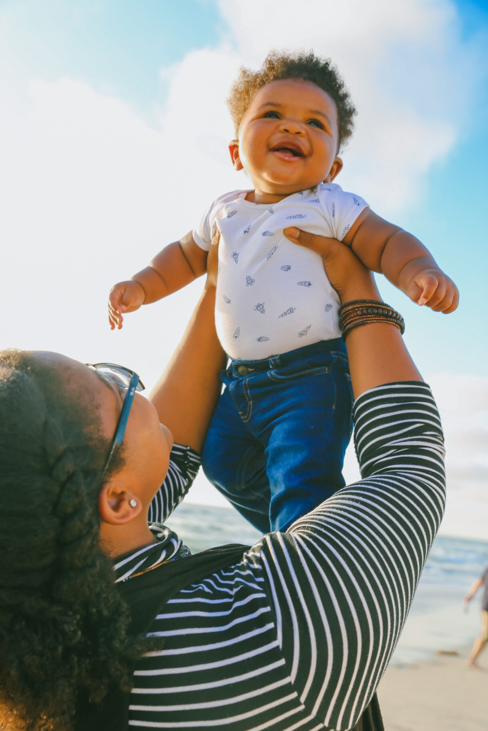 A baby in the arms of their mother, being raised in the air