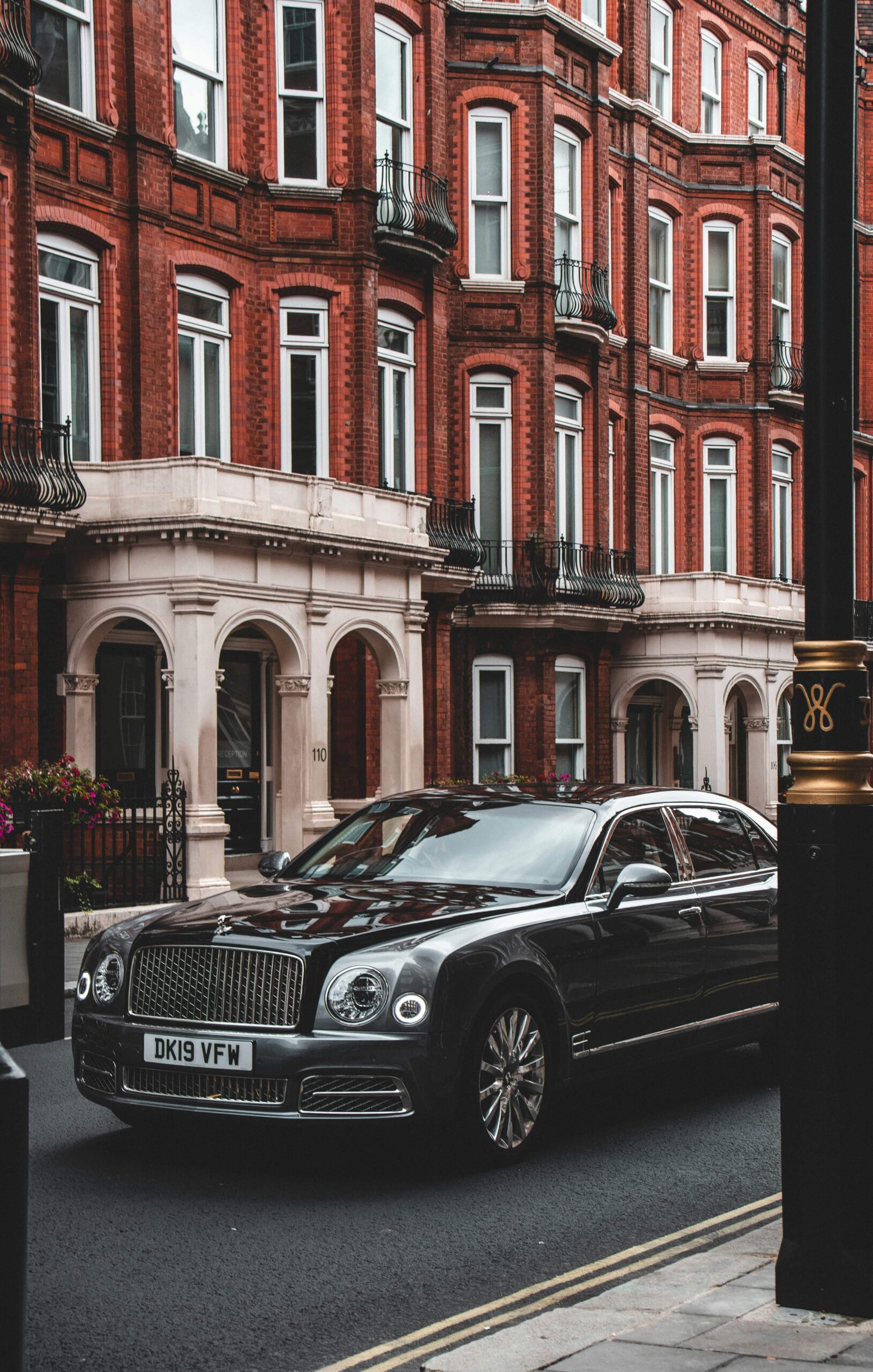 Black Bentley car parked outside a home in London.