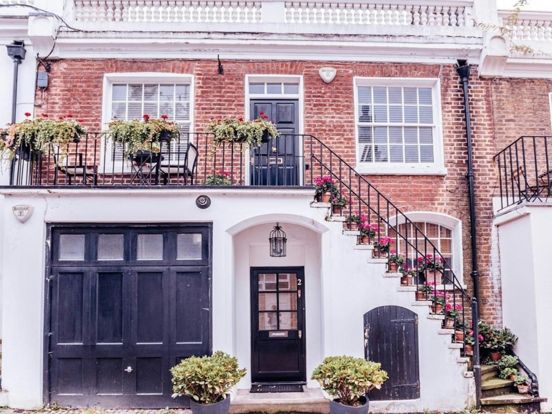 A mews house in Chelsea, with red brick and a black front door